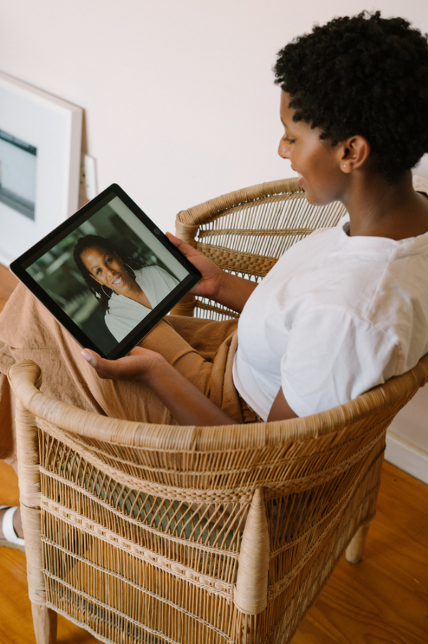 Doctor waving at senior patient during telehealth call